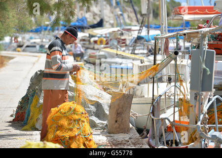 Fisherman mending moustiquaires Gaios. Paxos Grèce Banque D'Images