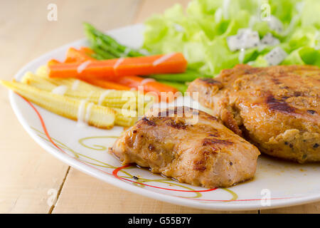 Les steaks grillés sur un plat blanc avec salade Banque D'Images