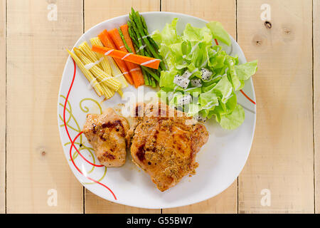 Les steaks grillés sur un plat blanc avec salade Banque D'Images