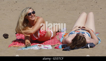 Laura Henderson (à gauche) et Megan McCalley (à droite) Profitez du temps chaud sur Portobello Beach près d'Édimbourg en Écosse. Banque D'Images