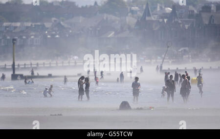 L'eau de mer s'évapore tandis que les gens apprécient le temps chaud sur la plage de Portobello, près d'Édimbourg, en Écosse. Banque D'Images