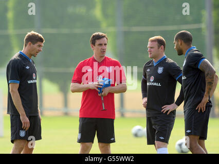 Gary Neville (au centre), entraîneur adjoint de l'Angleterre, discute avec Steven Gerrard (à gauche), Wayne Rooney (au deuxième rang à droite) et Glen Johnson pendant l'entraînement Banque D'Images