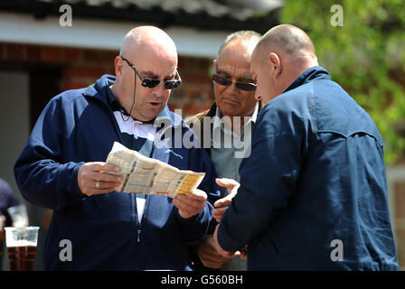 Courses hippiques - Betfred Derby Trial Day - Lingfield Park. Racegoers étudie la dernière forme dans le Racing Post Banque D'Images