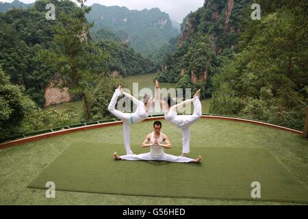 Les Griffin, dans la province de Hunan. 21 Juin, 2016. Les amateurs de yoga la pratique du yoga à l'endroit pittoresque Lac Chongde dans Zhangjiajie, Chine centrale est la province du Hunan, le 21 juin 2016. Le 21 juin marque la Journée Internationale de Yoga. Credit : Wu Yongbing/Xinhua/Alamy Live News Banque D'Images