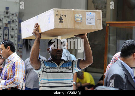 Le Caire, Égypte. 21 Juin, 2016. Antiquités égyptiennes portent des fonctionnaires d'un couvercle d'un sarcophage à son arrivée au Musée égyptien du Caire, Égypte, le 21 juin 2016. Deux anciennes sarcophage égyptien ont été livrés à la Musée égyptien du Caire après elles remontaient à une vente aux enchères en Israël. Antiquités Ministre Khaled el-Anani dit la couverture en bois colorés, décorés de hiéroglyphes et d'illustrations, ont été récupérés après qu'ils ont été mis en vente en 2012 et est retourné à la suite de la coopération entre les deux pays et d'Interpol © Amr Sayed/APA/Images/fil ZUMA Alamy Live News Banque D'Images