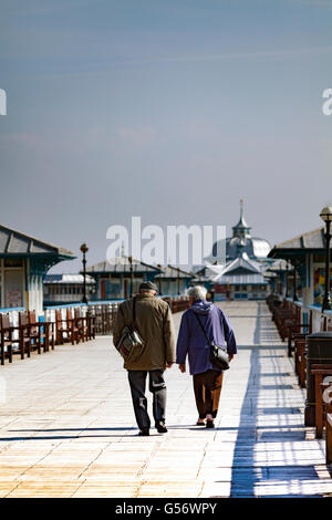 Un couple de personnes âgées bénéficiant d'une promenade sur les planches de la jetée de Llandudno, au nord du Pays de Galles, Royaume-Uni Banque D'Images