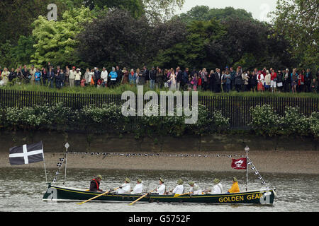 Les foules se rassemblent sur les rives de la rivière tandis que des bateaux s'alignent pour le début du Diamond Jubilee River Pageant sur la Tamise à Londres. Banque D'Images