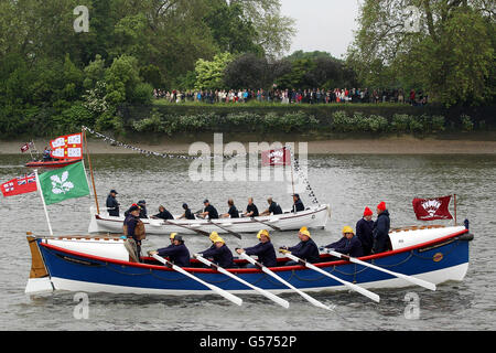 Les foules se rassemblent sur les rives de la rivière tandis que des bateaux s'alignent pour le début du Diamond Jubilee River Pageant sur la Tamise à Londres. Banque D'Images