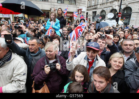 Les membres du public attendent d'avoir un aperçu du Prince de Galles et de la duchesse de Cornouailles, alors qu'ils assistent au « Big Jubilee Lunch » à Piccadilly, Londres, devant le Diamond Jubilee River Pageant. Banque D'Images