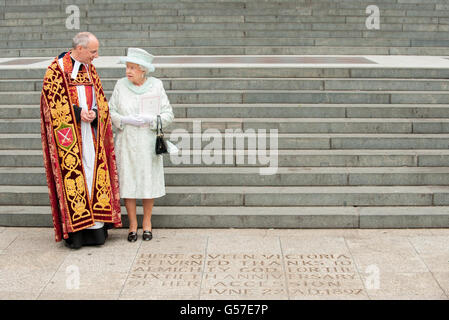 La reine Elizabeth II voit une inscription au pied des marches de la cathédrale Saint-Paul, dans le centre de Londres, à côté du doyen de St-Paul, le Dr David Ison, à la suite d'un service d'action de grâce. Banque D'Images