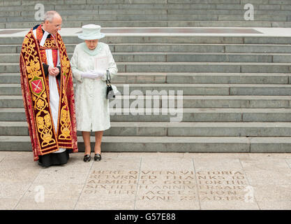 La reine Elizabeth II voit une inscription au pied des marches de la cathédrale Saint-Paul, dans le centre de Londres, à côté du doyen de St-Paul, le Dr David Ison, à la suite d'un service d'action de grâce. Banque D'Images