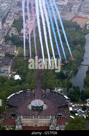 Les flèches rouges survolent en formation le palais de Buckingham à Londres tandis que la famille royale se trouve sur le balcon. Banque D'Images