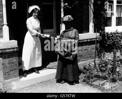 Une femme de ménage reçoit un paquet de Mme Nora Willis, la post-femme d'Epsom à Surrey.Les femmes ont rempli les postes vacants créés par les hommes qui sont partis au service de la première Guerre mondiale. Banque D'Images