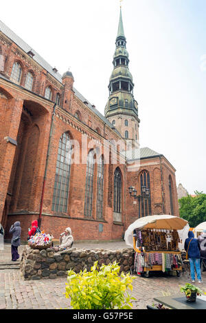 RIGA, Lettonie - JUIN 10,2016 : une rue dans le centre historique de Riga. Dans l'arrière-plan est le clocher de l'église Saint Pierre Banque D'Images