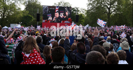 Les foules regardent Robbie Williams inaugurer ce soir le Diamond Jubilee concert sur les grands écrans du Mall. Banque D'Images