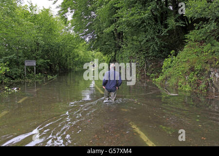 Un homme marche à travers les eaux d'inondation à Machynlleth à Powys, pays de Galles, après de graves inondations ont frappé l'ouest du pays de Galles. Banque D'Images