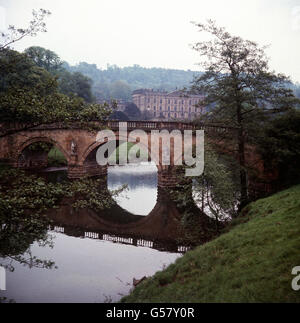 Le siège du duc de Devonshire à Chatsworth, Derbyshire. L'eau d'un grand réservoir sur l'amarrer est ramenée sur un cours d'eau pour travailler les fontaines sur le domaine. La photo montre Chatsworth House et le fleuve Derwent, la fin du voyage de l'eau. Banque D'Images