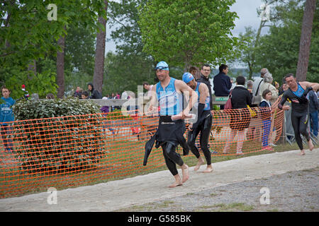 Les hommes de nageurs dans des combinaisons allant du lac lors de mimizam triathlon france Banque D'Images