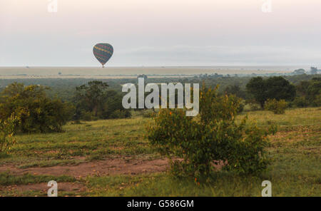 Tôt le matin à l'aube d'une montgolfière est de glisser sur la savane dans le Masai Mara, Kenya, Afrique Banque D'Images