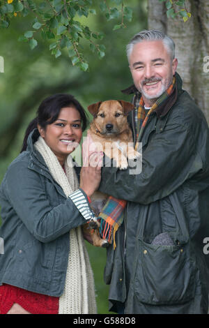 Portrait d'un couple avec leur chien tandis que dehors sur une marche. Banque D'Images