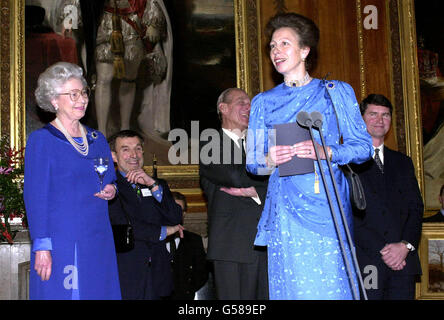 La princesse royale s'adresse à une fête au château de Windsor, tenue en l'honneur de son 50e anniversaire par la reine, à laquelle assistent des invités d'organismes de bienfaisance et d'organismes dont la princesse est le patron. Son mari, le commandant Tim Laurence, est à droite. Banque D'Images