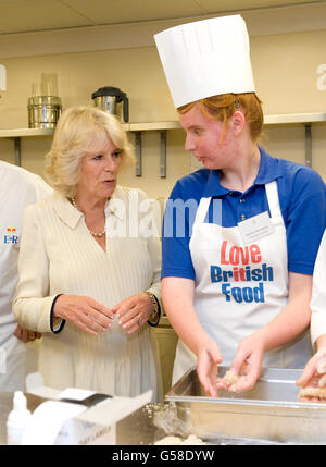 La duchesse de Cornouailles parle à Sequoia Trevochrow (r) un élève de l'école Cape Cornwall, dans les cuisines de Buckingham Palace, dans le centre de Londres. Banque D'Images