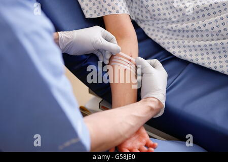 Nurse putting bandages sur un patient avec suture de la fermeture d'un blessure. Banque D'Images