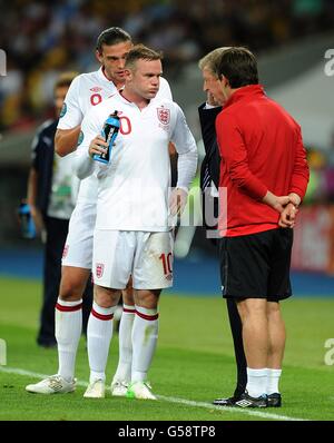 Roy Hodgson, directeur de l'Angleterre (deuxième à droite), et Gary Neville, entraîneur, parlent avec Wayne Rooney (deuxième à gauche) et Andy Carroll (gauche) sur la ligne de contact. Banque D'Images