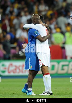 Joleon Lescott en Angleterre et Mario Balotelli en Italie (à gauche) partagent un accolade après le match Banque D'Images