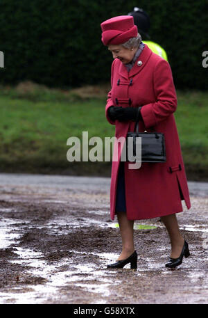 La reine Elizabeth II observe son pas à l'extérieur de l'église Saint-Pierre, Saint-Paul à West Newton, Norfolk. Un Walter Raleigh moderne n'était nulle part vu que la Reine négociait une série de flaques délicates tout en quittant l'église après un service. Banque D'Images