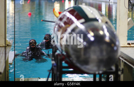 Les étudiants en ingénierie de l'université TEXAS A&M attendent que leur sous-marin à propulsion humaine, Maroon Harpoon, soit descendu dans l'eau avant de courir au réservoir d'essai Ocean Basin de Qinetiq à Gosport, dans le Hampshire. L'artisanat, propulsé seulement par la personne à l'intérieur doit naviguer un cours en forme de chaussure de cheval comprenant une section de slalom. Banque D'Images