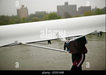 Un rameur aide à transporter un bateau retour à la Peter Jay Sharp boathouse après course à New York City, USA, 30 avril 2005. Banque D'Images