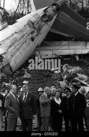 Le Premier ministre Margaret Thatcher, le président de British Midland Michael Bishop (au centre, bras levé) et le secrétaire d'Irlande du Nord Tom King (deuxième à partir de la gauche) visitent la scène de l'écrasement d'avion du Boeing 737 sur le côté de l'autoroute M1 près de Kegworth, Leicestershire. Banque D'Images