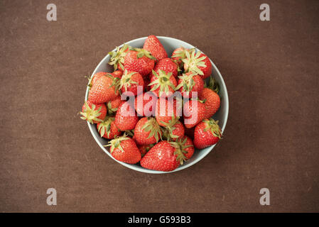 Pile de mûres juteuses fraises biologiques frais dans un grand bol bleu. Fond sombre. L'espace vide Banque D'Images