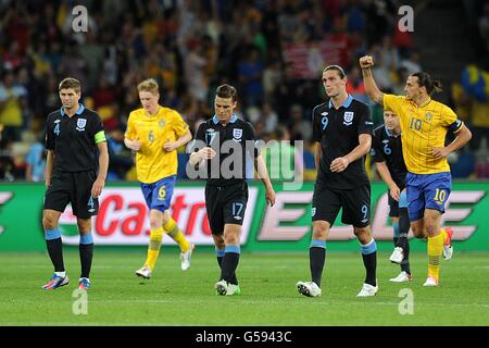 Le suédois Zlatan Ibrahimovic (à droite) célèbre son deuxième but alors que les joueurs d'Angleterre Steven Gerrard, Scott Parker et Andy Carroll (de gauche à droite) remarchent vers leur demi-abattu Banque D'Images