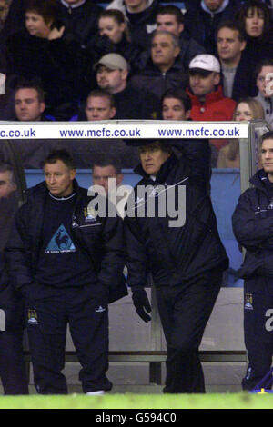Joe Royle, directeur de Manchester City (au centre) et Asa Hartford, entraîneur (à gauche), regardent du dugout pendant que leurs côtés perdent à la maison quatre buts à Leeds United, lors de leur match de football FA Premiership à Maine Road, à Manchester. Banque D'Images