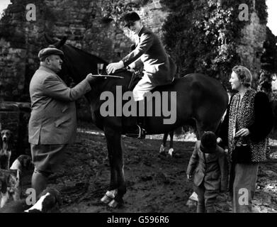 CHASSE AU RENARD 1947: À la rencontre de l'East Sussex Foxhounds à court Lodge Farm, Crowhurst, Sussex, Lord Burghley prend une coupe d'étrier de M. T.W.Croft (le propriétaire), regardé par Lady Burghley et Little Ann Croft. Banque D'Images