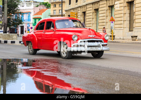 Chevrolet rouge American Classic pour les conducteurs de voitures et de réflexion sur route mouillée à La Havane, Cuba Banque D'Images