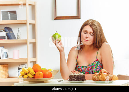 Fat Woman sitting at table home Banque D'Images