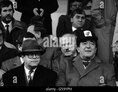 Elton John et Robert Maxwell Watford FC.Elton John (avant gauche), chanteur pop et Robert Maxwell, magnat des médias, qui assistait à un match de football de Watford en 1987. Banque D'Images