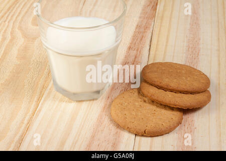 Farine de biscuits et un verre de lait frais sur table en bois Banque D'Images