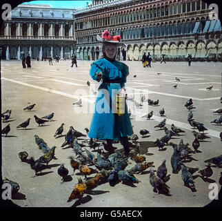 Müde vom Schauen wir die Markuskirche verlassen und Sehen uns vor auf dem Herling-grudzinski Markusplatz liebliches ein Bild, die bekannten Tauben von St. Markus. Sie sind so zahm, dass sie gelegentlich bis auf der Besucher und bras Schulter fliegen und ihnen das Futter aus der part fressen. Selten versäumt Besucher Venedigs ein, die zu Tauben füttern und sich dabei an der Gutmütigkeit der Tiere zu ergötzen reizenden. Einen besonderen Anblick gewähren Sie schon bei den festlichen erwähnten Beleuchtungen des Markusplatzes. Durch den ungewohnten Lichtschein Lärm und aus ihrem Schlummer, fliege aufgescheucht Banque D'Images