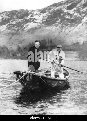 Forcé de prendre un bateau à rames au lieu de son embarcation à grande vitesse « Bluebird », en raison d'un attelage de dernière minute, Donald Campbell (l) et son mécanicien en chef Leo Villa (r) vont inspecter la zone de dérapage d'Ullswater, Cumberland. Banque D'Images