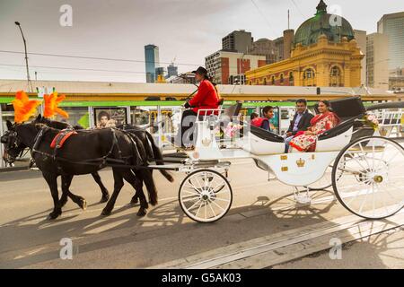 Une calèche traverse en face de la gare de Flinders Street, ville de Melbourne, Australie Banque D'Images