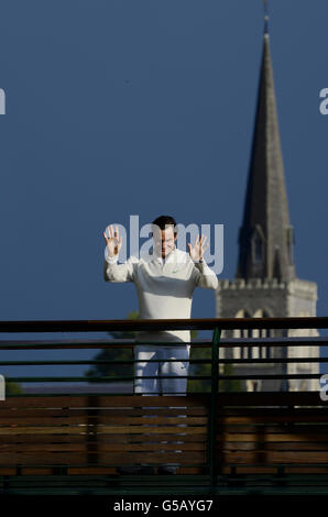 Roger Federer, de Suisse, se délasse de la foule depuis le balcon près de Center court, avec l'église de Wimbledon en arrière-plan pendant le treize jour des championnats de Wimbledon 2012 au All England Lawn tennis Club, Wimbledon. Banque D'Images