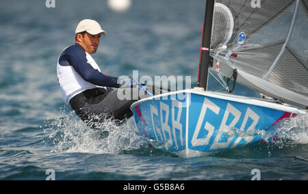 Ben Ainslie, en Grande-Bretagne, pratique son canot Finn sur la baie de Weymouth près de la gravure à la craie de George III Sa première course compétitive est demain. Banque D'Images