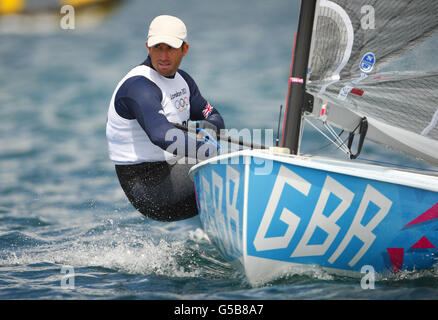 Ben Ainslie, en Grande-Bretagne, pratique son canot Finn sur la baie de Weymouth près de la gravure à la craie de George III Sa première course compétitive est demain. Banque D'Images