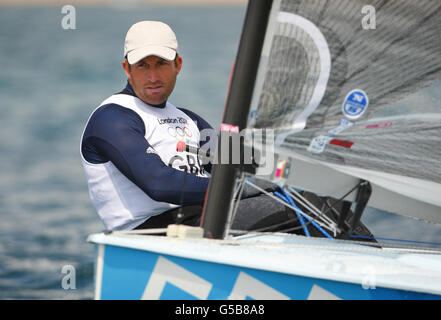 Ben Ainslie, en Grande-Bretagne, pratique son canot Finn sur la baie de Weymouth près de la gravure à la craie de George III Sa première course compétitive est demain. Banque D'Images