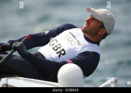 Ben Ainslie, en Grande-Bretagne, pratique son canot Finn sur la baie de Weymouth près de la gravure à la craie de George III Sa première course compétitive est demain. Banque D'Images