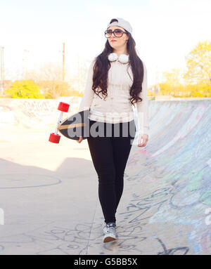 Jeune femme avec son skateboard au skatepark Banque D'Images